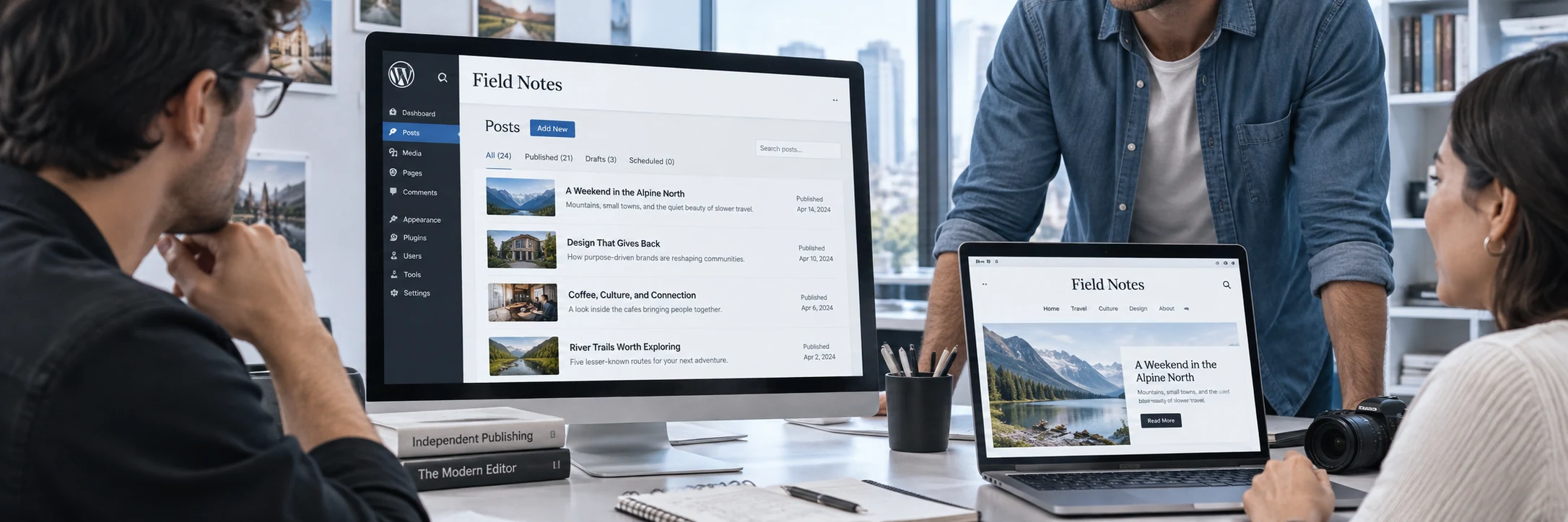 Wide contextual scene of an editorial team collaborating around a desktop and laptop displaying a fictional 'Field Notes' WordPress publication